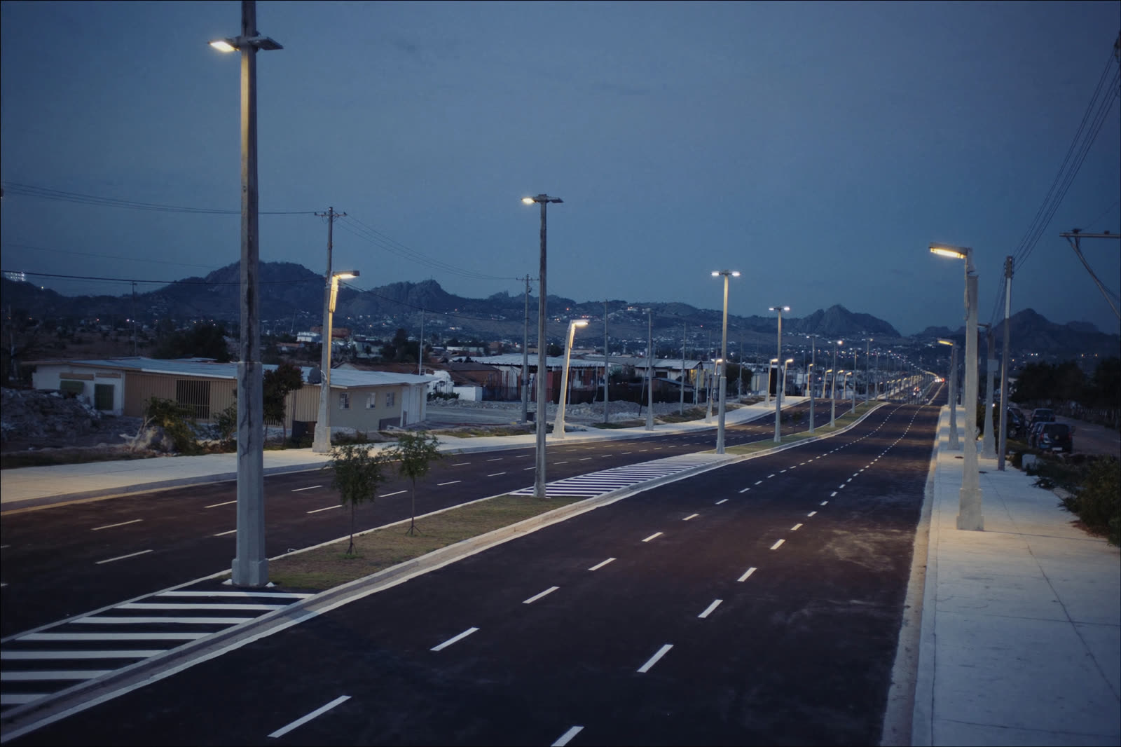 Avenida de cuatro carriles con señalamiento horizontal y alumbrado público
